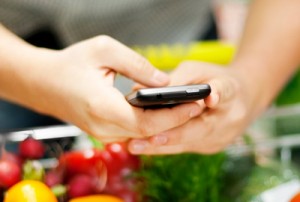 Woman grocery shopping with mobile phone